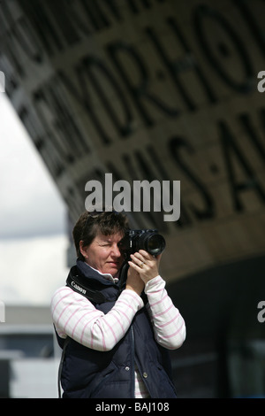 Stadt von Cardiff, Wales. Lady-Fotograf mit Jonathan Adams entworfen Wales Millennium Centre im Hintergrund. Stockfoto