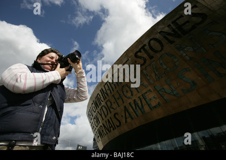 Stadt von Cardiff, Wales. Lady-Fotograf mit Jonathan Adams entworfen Wales Millennium Centre im Hintergrund. Stockfoto