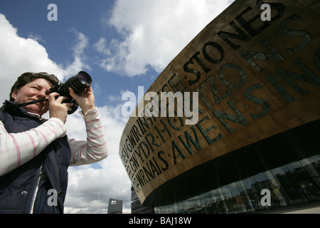 Stadt von Cardiff, Wales. Lady-Fotograf mit Jonathan Adams entworfen Wales Millennium Centre im Hintergrund. Stockfoto