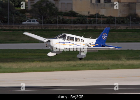 Piper PA-28 Warrior II-Motor Licht privaten Flugzeug fliegen tief über die Start- und Landebahn Stockfoto