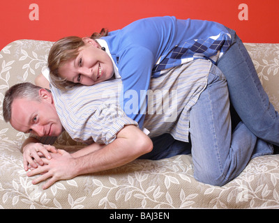 Junge Brautpaar posiert auf sofa Stockfoto