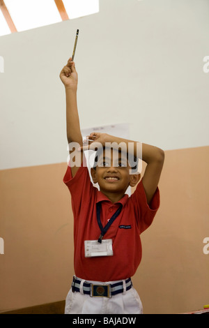 Kind mit erhobener Hand in der Schule in Hazira, in der Nähe von Surat. Gujarat. Indien Stockfoto