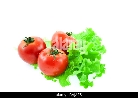 drei rote Tomaten auf Salatblätter weißer Hintergrund Stockfoto