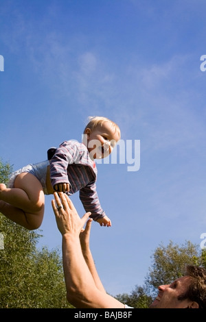 kleiner Junge lachend und in die Luft geworfen und gefangen in Papas Hände Stockfoto