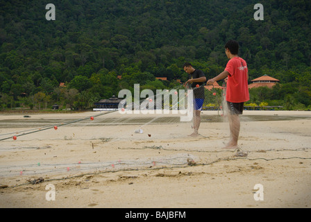 Malaysische Fischer Überprüfung ihr Netz für Fische an einem Strand in der Nähe von Berjaya Resort in Langkawi Stockfoto