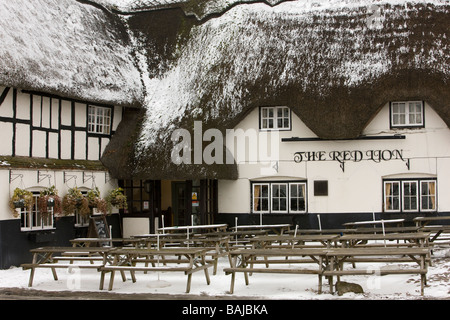 Das Red Lion Pub Strohdach abgestaubt im Schnee in der Mitte des Dorfes Avebury Stockfoto