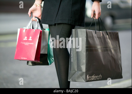 Einkaufstaschen aus exklusiven Geschäften durchgeführt von einer jungen Frau in Soho in London Stockfoto