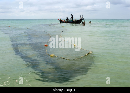 Fischer fangen Fische in Ufernähe mit Netzen. Stockfoto