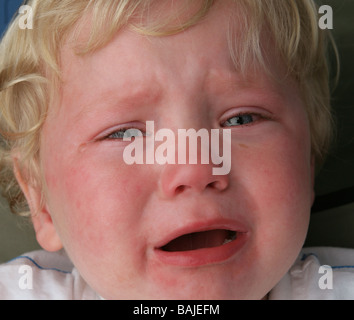 Blonde kurzhaarige Kind weint mit Tränen in den Augen. Stockfoto