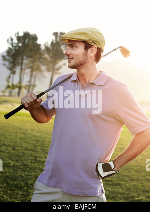 Junge männliche Golfer stehen auf Kurs, Schulter Club festhalten Stockfoto