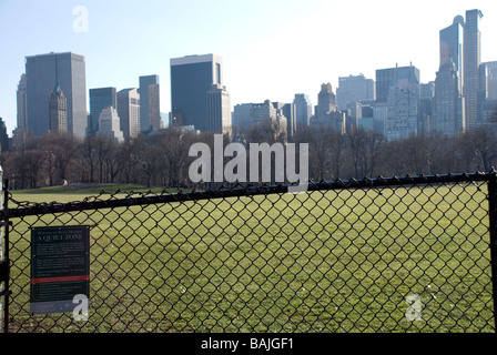 "Ruhige Zone" auf einem Schild am umzäunten Sheep Meadow im Central Park mit der New Yorker Skyline im Hintergrund in USA Stockfoto