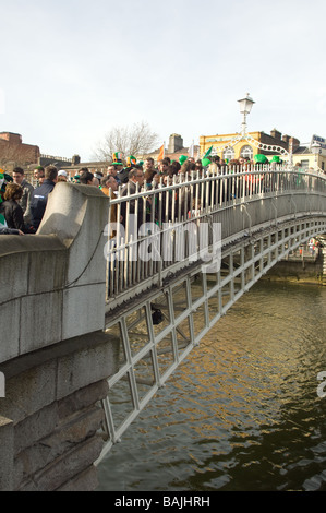 Menschenmassen überqueren Half Penny Bridge am St. Patricks Day in Dublin, Irland Stockfoto