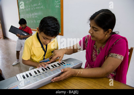 Kinder/Kinder/Kinder und Lehrer in einer Musikklasse in der Schule in Hazira, in der Nähe von Surat. Gujarat. Indien. Stockfoto