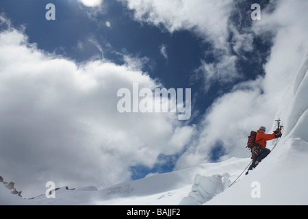 Bergsteiger, die verschneiten Hang hinauf, mit Achsen Stockfoto