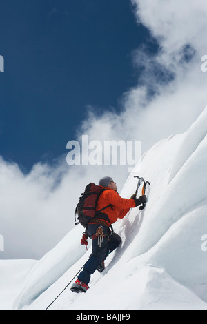 Bergsteiger, die verschneiten Hang hinauf, mit Achsen Stockfoto