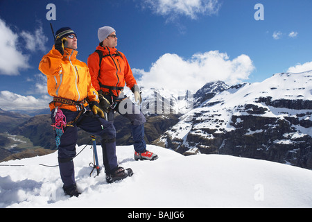 Zwei Bergsteiger am schneebedeckten Gipfel Stockfoto