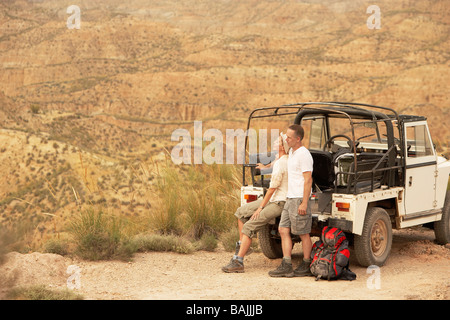 Paar sitzt auf der Rückseite vier-Rad-Antrieb-Auto am Rande der Klippen in der Wüste Stockfoto