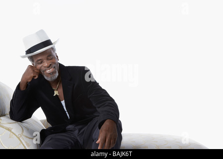 Mann in Fedora auf Chaise Lounge Stockfoto