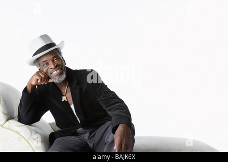 Mann in Fedora auf Chaise Lounge Stockfoto