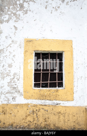 Kleine Fenster mit Gitterstäben in einer alten Kapelle. Crato, Alentejo, Portugal. Stockfoto