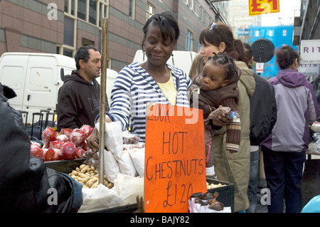 Mutter und Kind kaufen Chesnuts an Petticoat Lane Street Markeyt London England Stockfoto