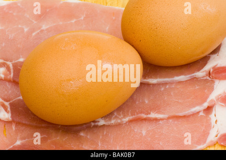 Frühstück zwei Eiern auf drei Speckscheiben Speckscheiben ungekocht zurück Stockfoto