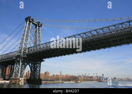 Williamsburg Bridge über den East River (Empire State Building im Hintergrund). Stockfoto