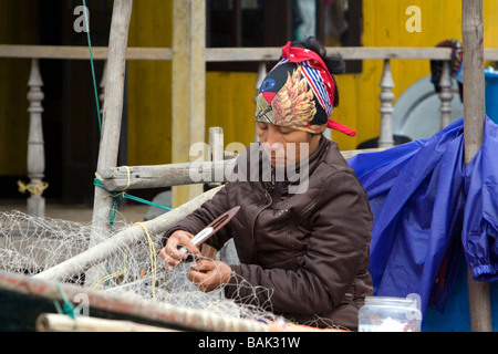 Vietnamesische Mann Reparatur Fischernetze in Ha Long Bay Vietnam Stockfoto