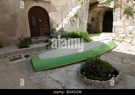 Ein kleines Holzboot im Hof eines Hauses in der Altstadt von Baska, Insel Krk, Kroatien Stockfoto