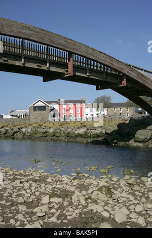 Stadt von Aberaeron, Wales. Holzbrücke über den Fluss Aeron mit bunt bemalten Häusern im Hintergrund. Stockfoto