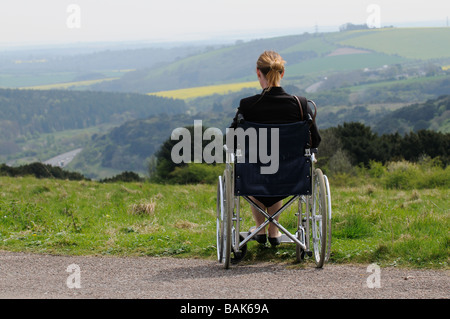 Frau Rollstuhlfahrer sitzen mit Blick auf einige englische Landschaft UK Stockfoto