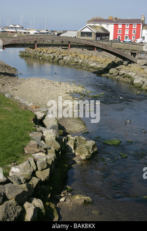 Stadt von Aberaeron, Wales. Holzbrücke über den Fluss Aeron mit bunt bemalten Häusern im Hintergrund. Stockfoto