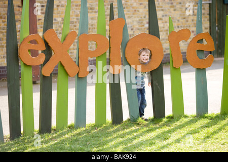 Ein Junge steckt seinen Kopf durch das "entdecken" Schild an die Wetlands Centre in London Stockfoto