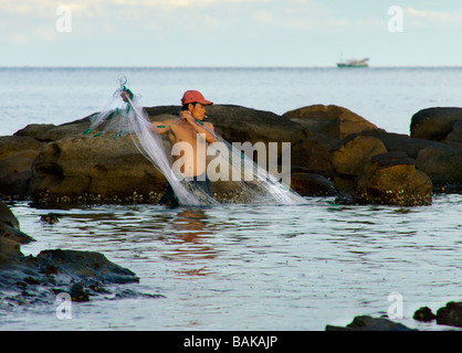 Fischer fangen Fische in Ufernähe mit Netzen. Stockfoto