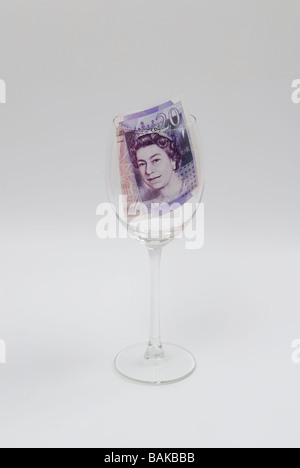 Zwanzig Pfund-Banknote in ein Trinkglas Stockfoto