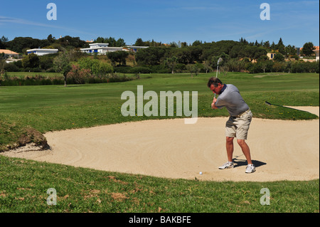 Männlichen Golfer aus einer Aufnahme in einem Sandfang Bunker auf dem Golfplatz Stockfoto