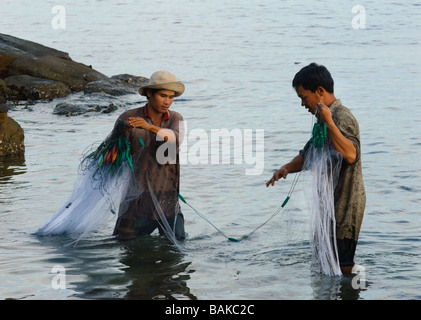 Fischer fangen Fische in Ufernähe mit Netzen. Stockfoto