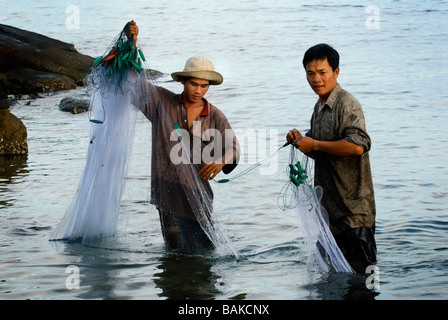 Fischer fangen Fische in Ufernähe mit Netzen. Stockfoto