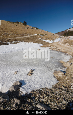 Gefrorene Pfütze in einem Berg bei hellen, sonnigen Tag Stockfoto