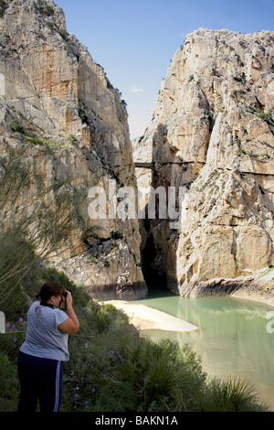 Eine weibliche Touristen fotografieren El Desfiladero de Los Gaitanes Schlucht oder Canyon, durch den Fluss Guadalhorce, in der Nähe von El Chorro geschnitzt, Stockfoto