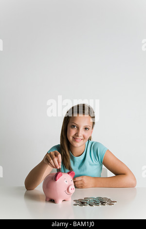 Mädchen mit Sparschwein und Münzen