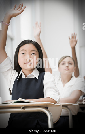 Schülerinnen und Schüler mit erhobenen Händen Stockfoto