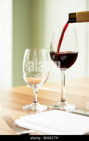 Rotwein wird in ein Weinglas gegossen Stockfoto