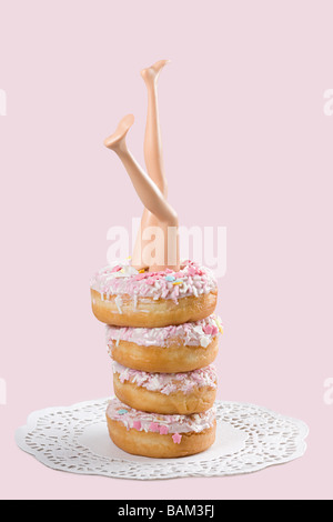 Puppe-Beine in einem Stapel von donuts Stockfoto