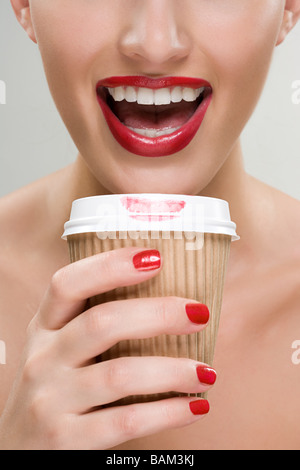 Frau trinkt Kaffee aus einem Pappbecher Stockfoto