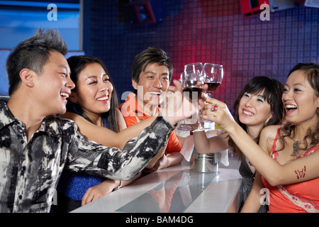 Gruppe von Freunden In einem Nachtclub, toasten Stockfoto