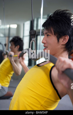 Junger Mann auf einem Heimtrainer in der Turnhalle Stockfoto