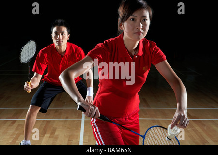 Junger Mann und Frau vorbereiten, ein Badminton-Schuss zurückzukehren Stockfoto