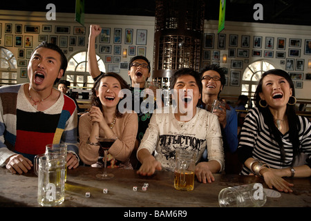 Glückliche junge Menschen beobachten Spiel Sports Bar Stockfoto