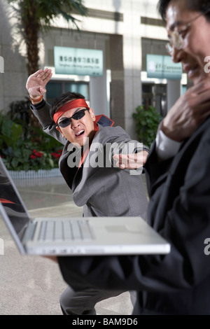 Geschäftsmann In Stirnband und eine Sonnenbrille tun Karate bewegt Stockfoto